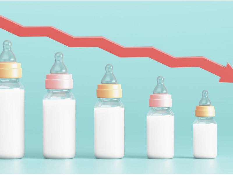 Symbolic image representing falling birth rates and declining fertility: baby bottles getting progressively smaller with a sharp red downward trend arrow