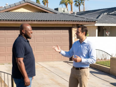 Thomas Moore and heir stand in a driveway outside a home in probate.